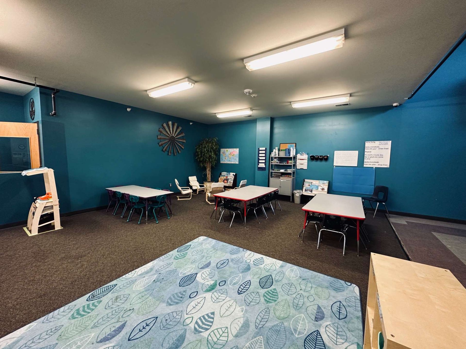 A room with blue walls and tables and chairs in it.