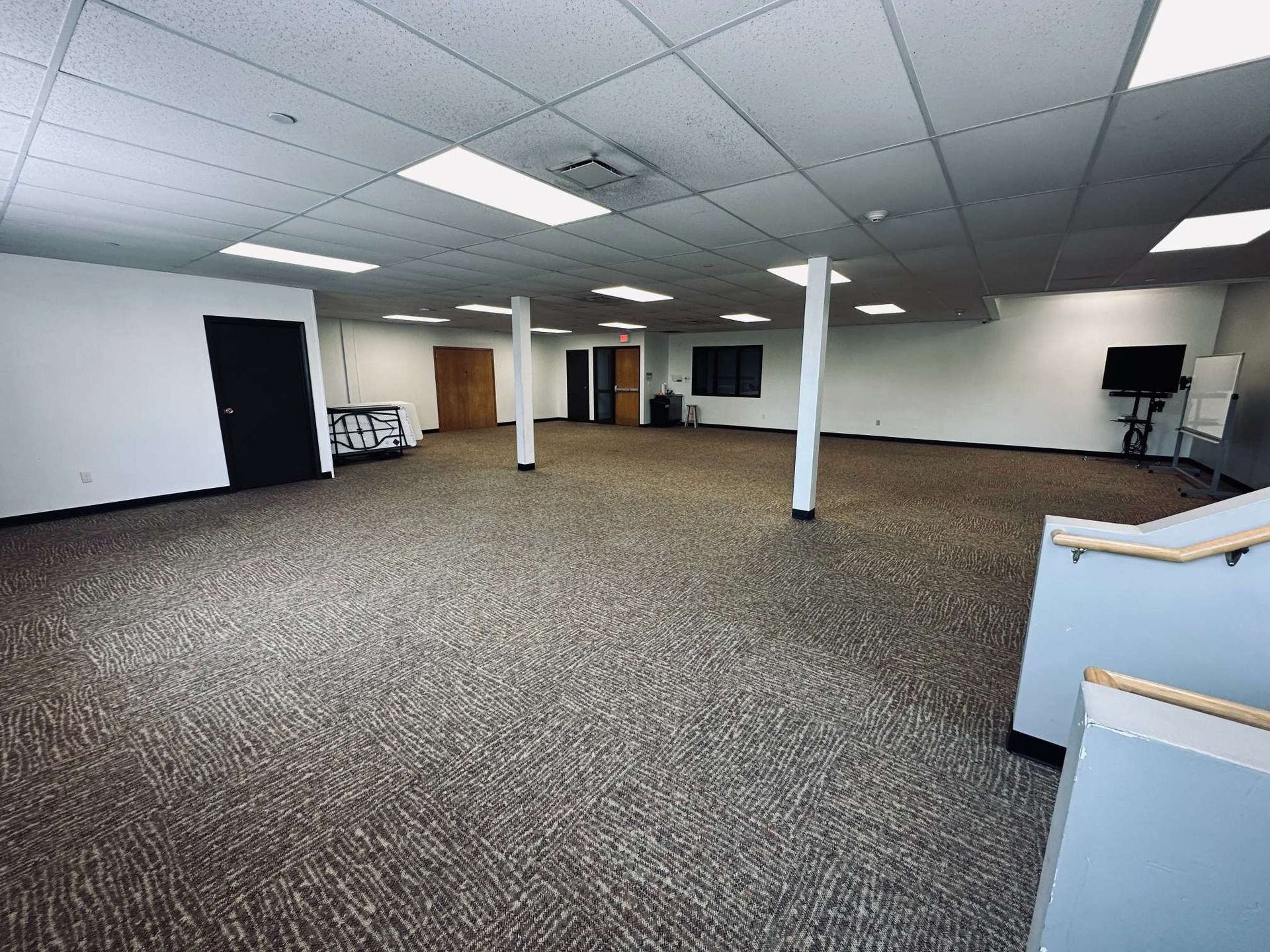 A large empty room with a carpeted floor and white walls.