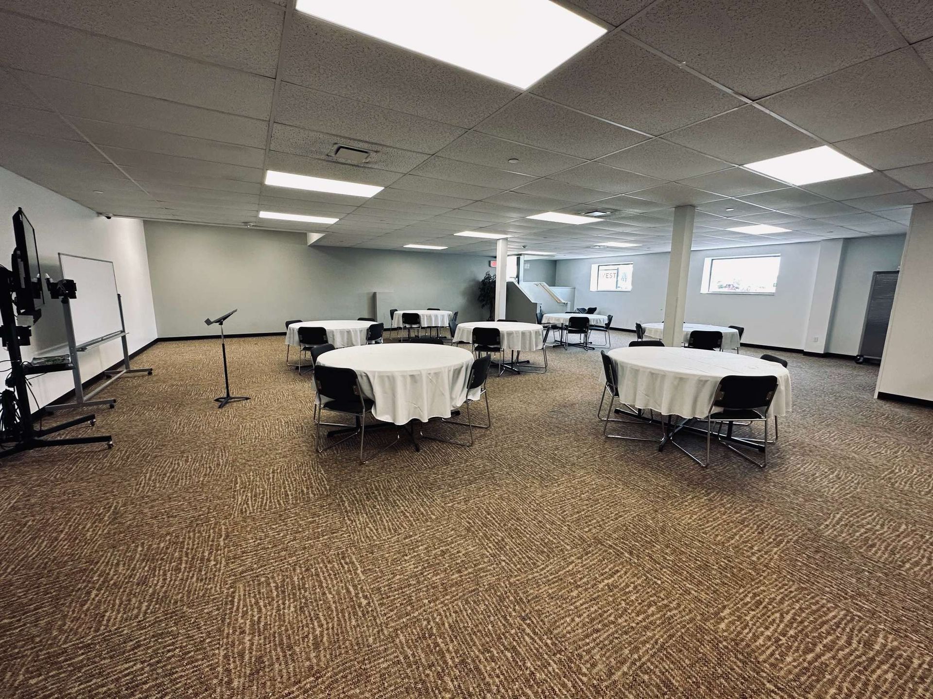 A large room with tables and chairs in it.