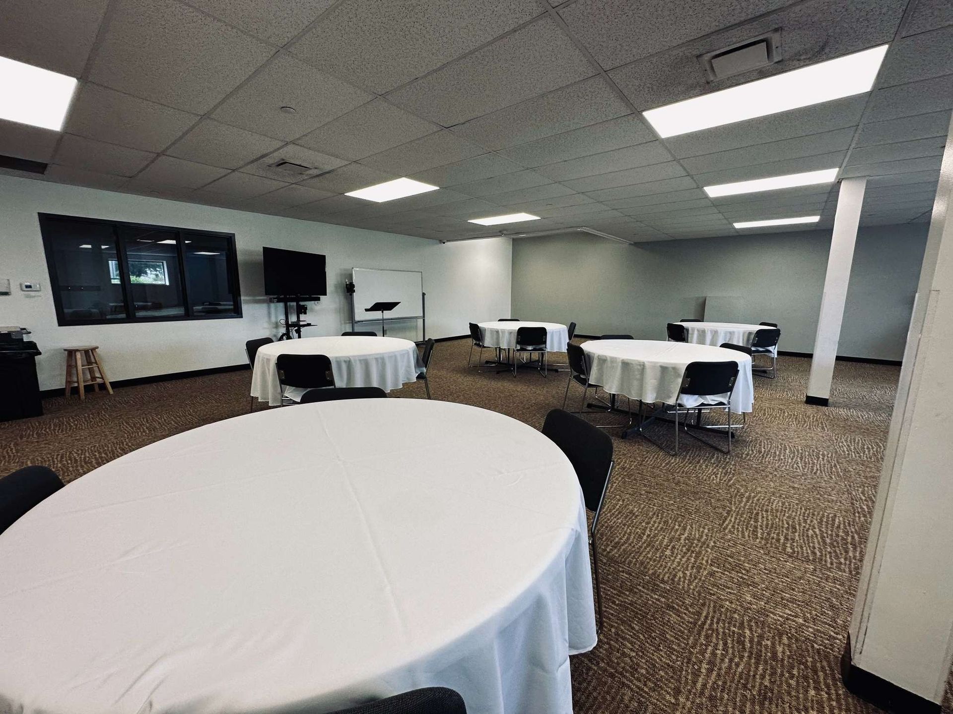 A large room with tables and chairs in it.