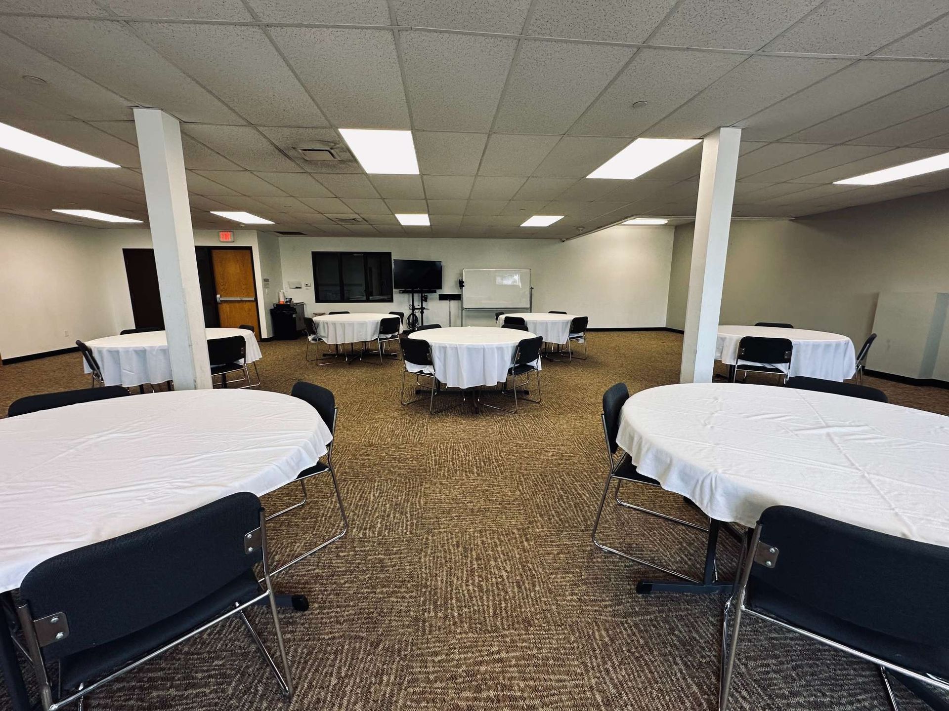 A large room with tables and chairs set up for a banquet.