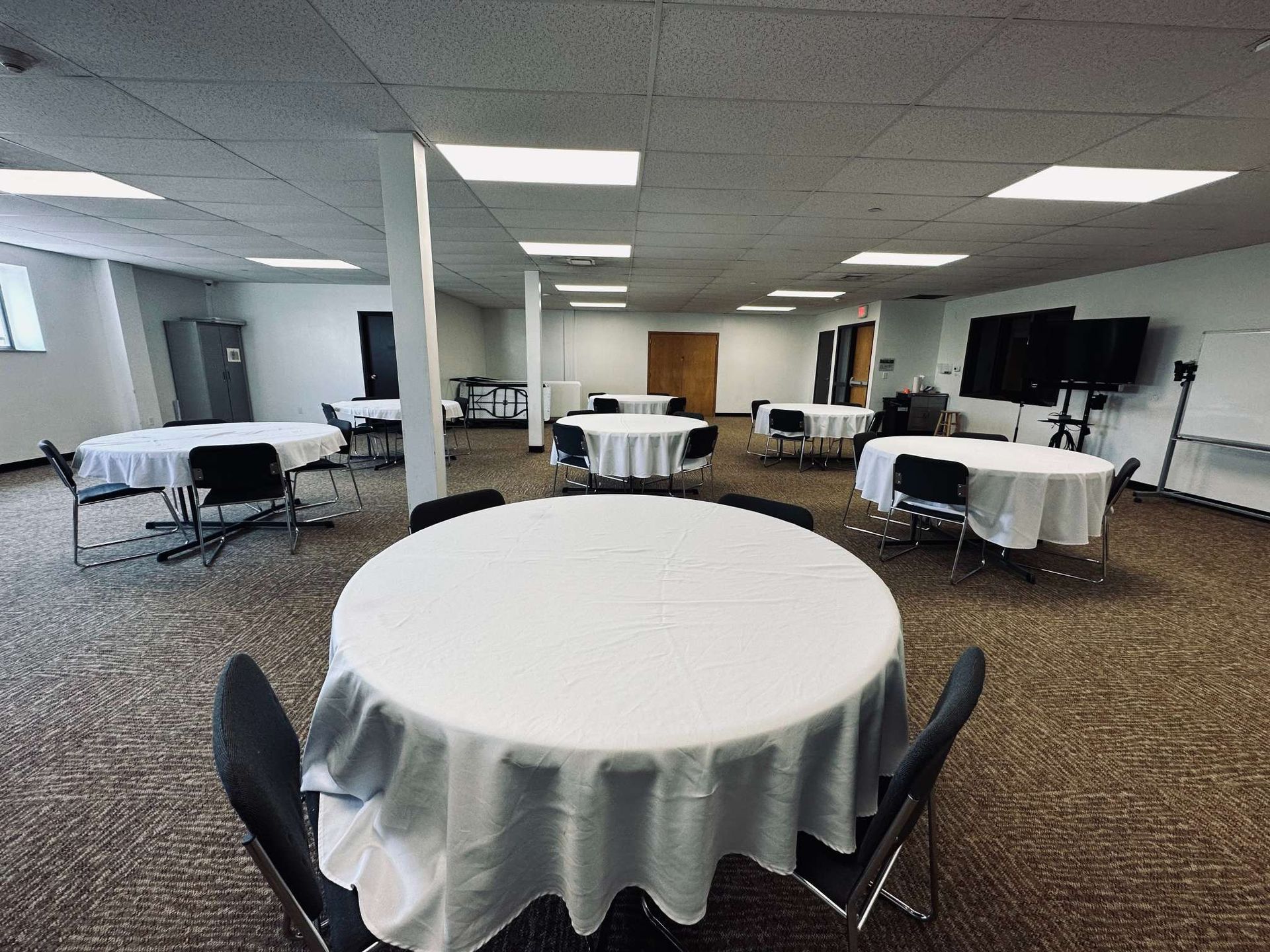 A large room with tables and chairs in it.