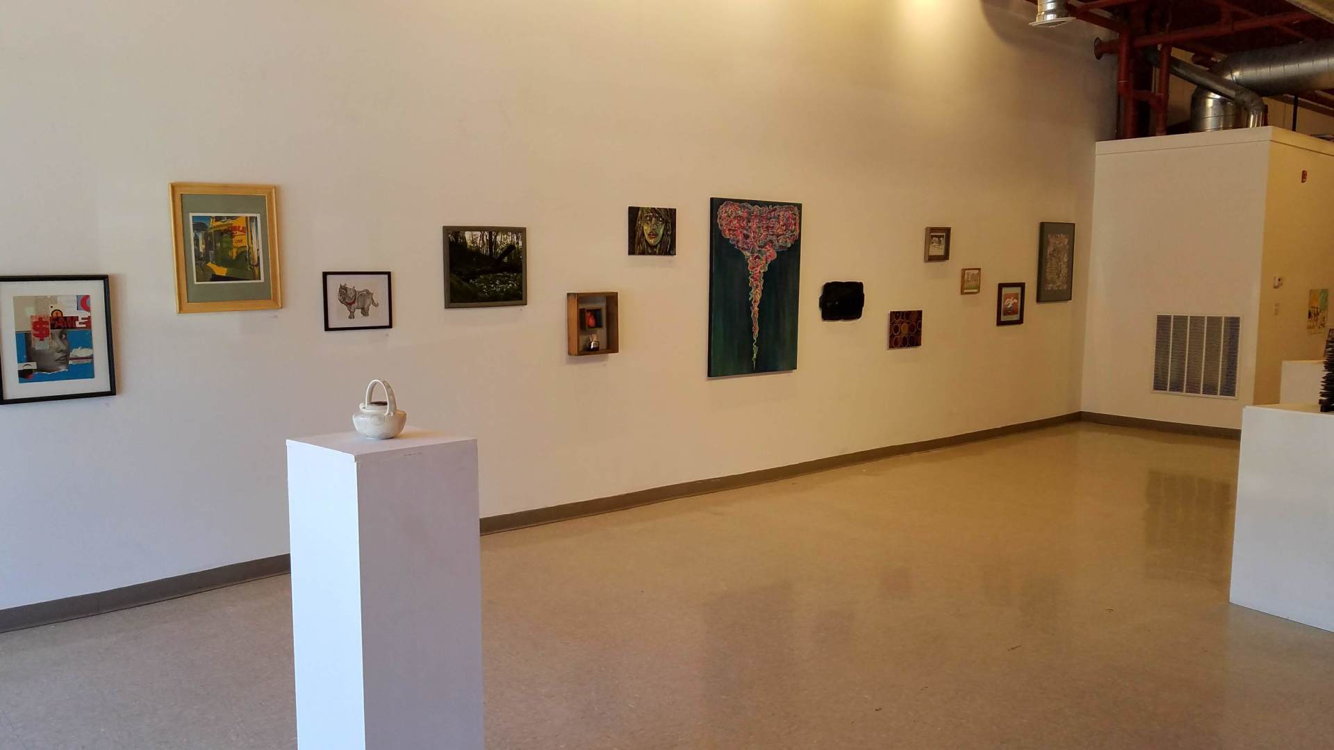 There are a lot of paintings on the wall in this room.