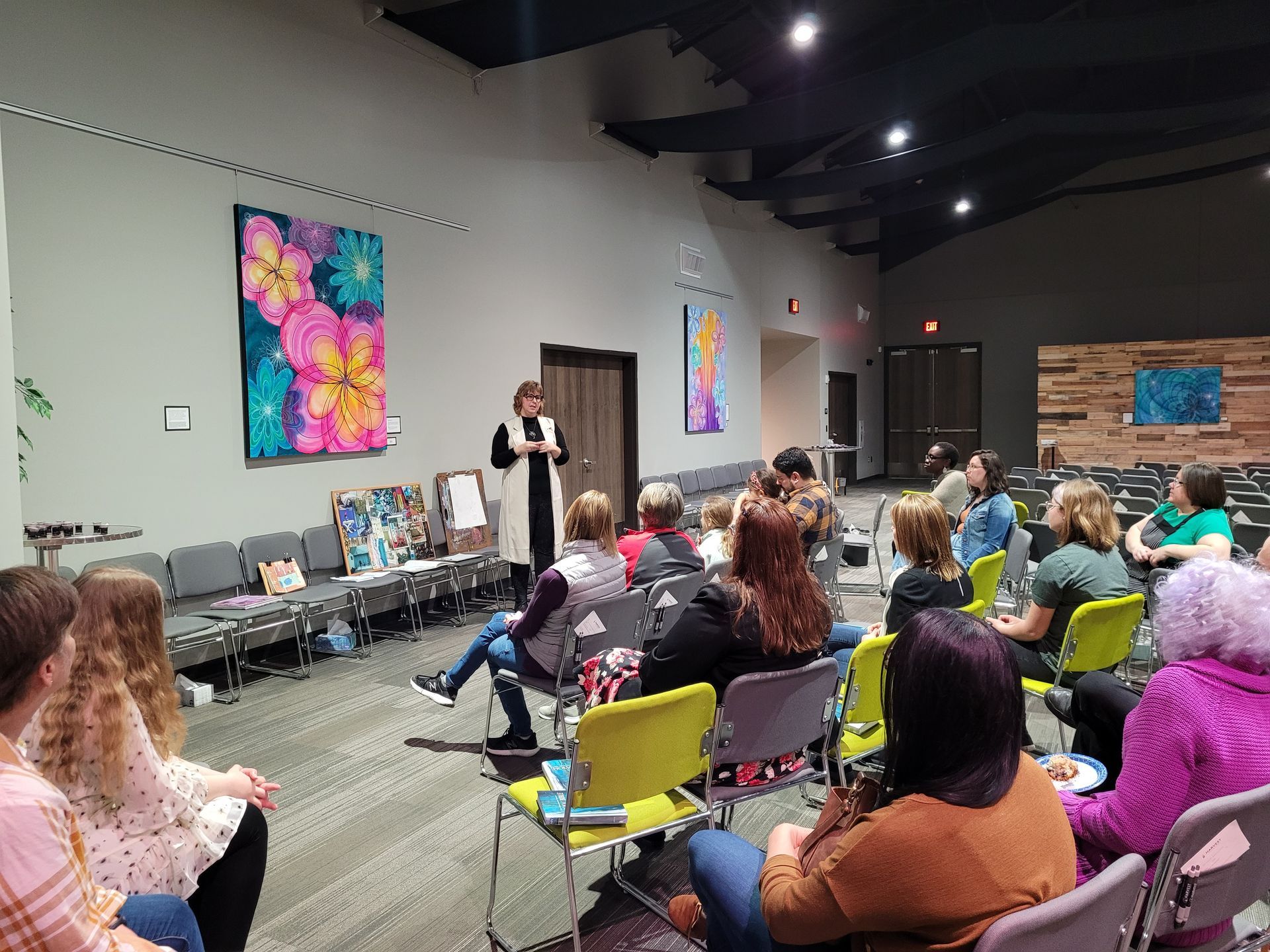 A woman is giving a presentation to a group of people sitting in chairs.