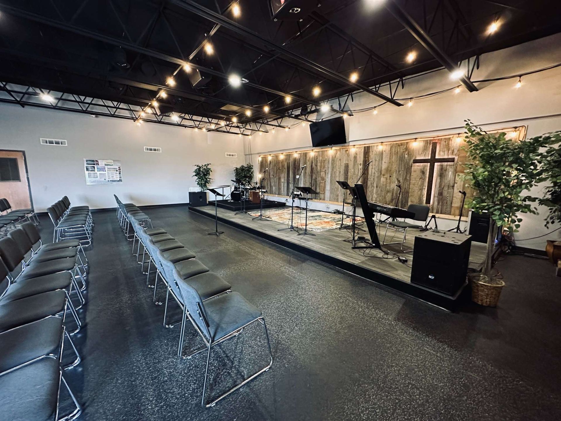 A large room with rows of chairs and a stage in the middle.