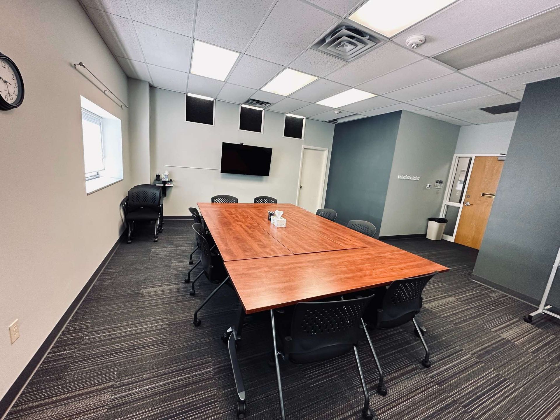 A conference room with a long wooden table and chairs.