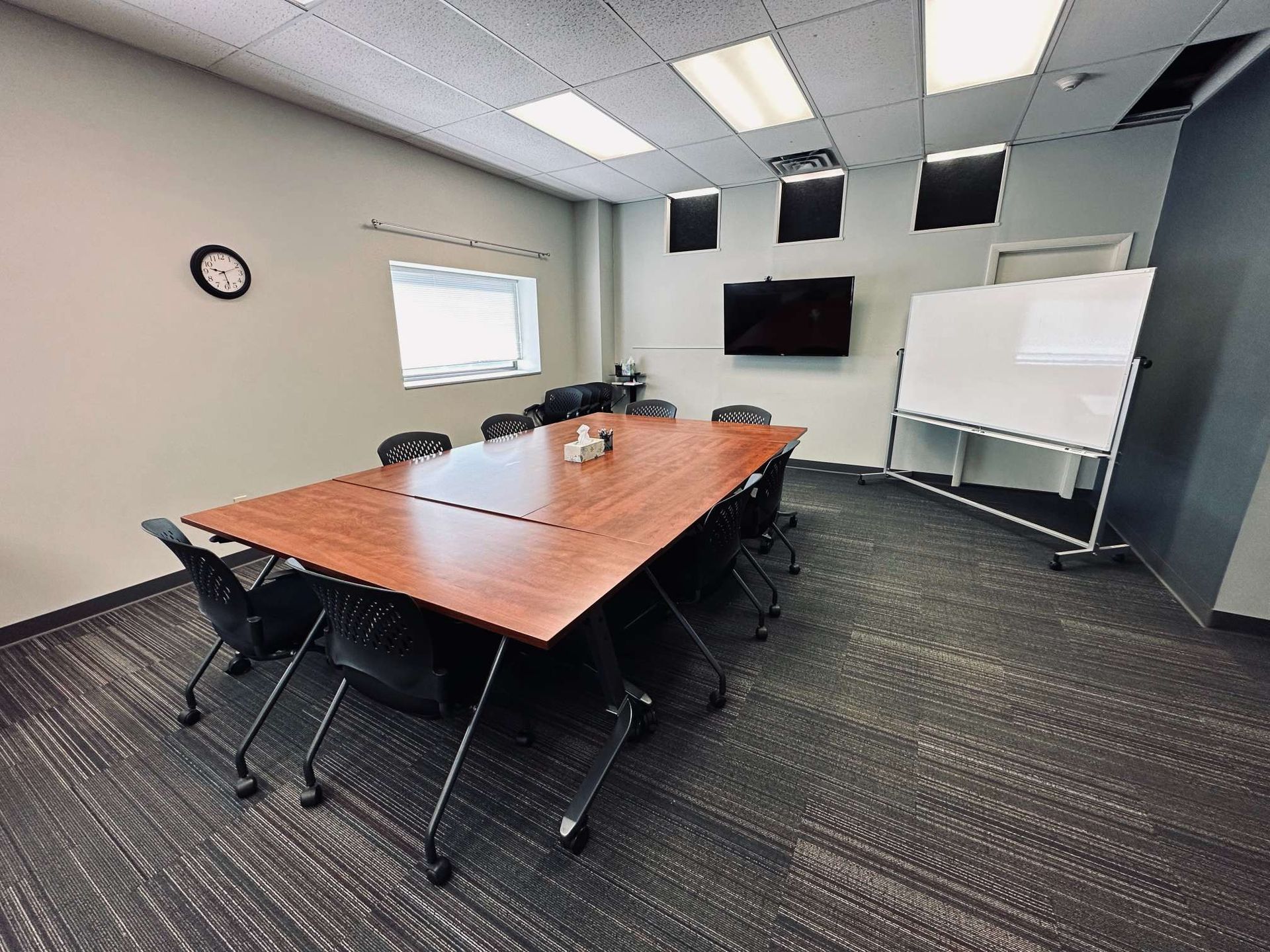 A conference room with a long table and chairs.