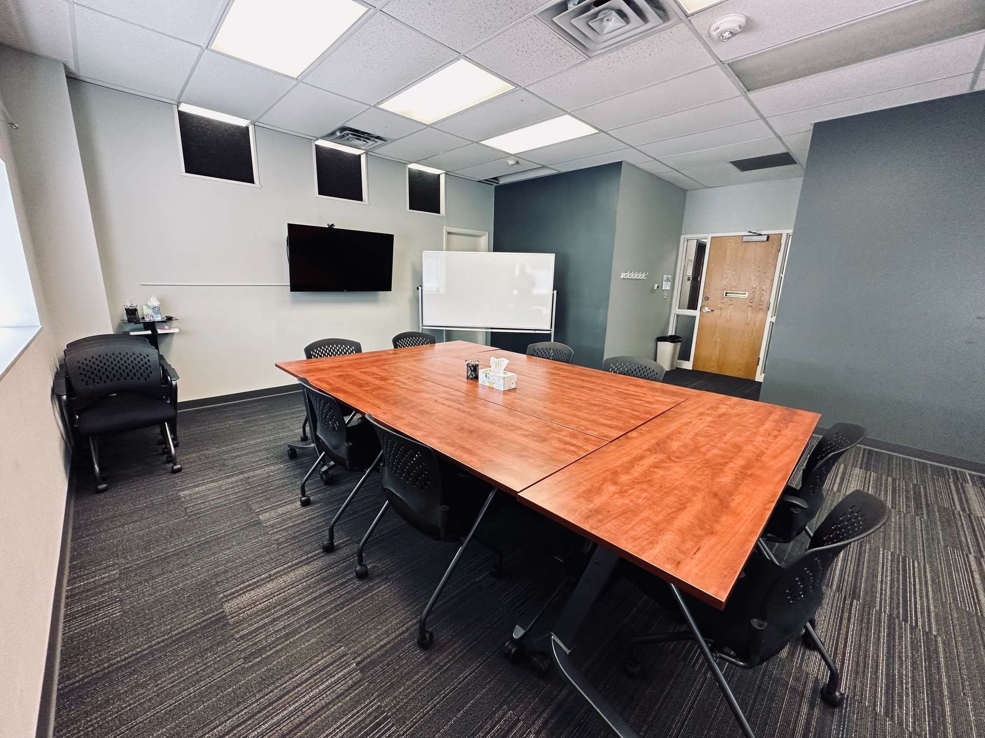 A conference room with a long wooden table and chairs.