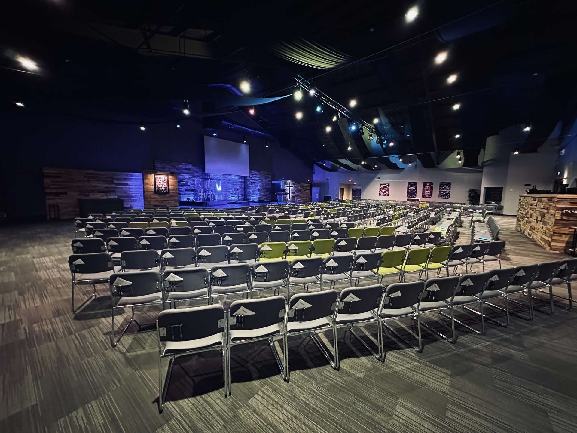 A large auditorium with rows of chairs in it.
