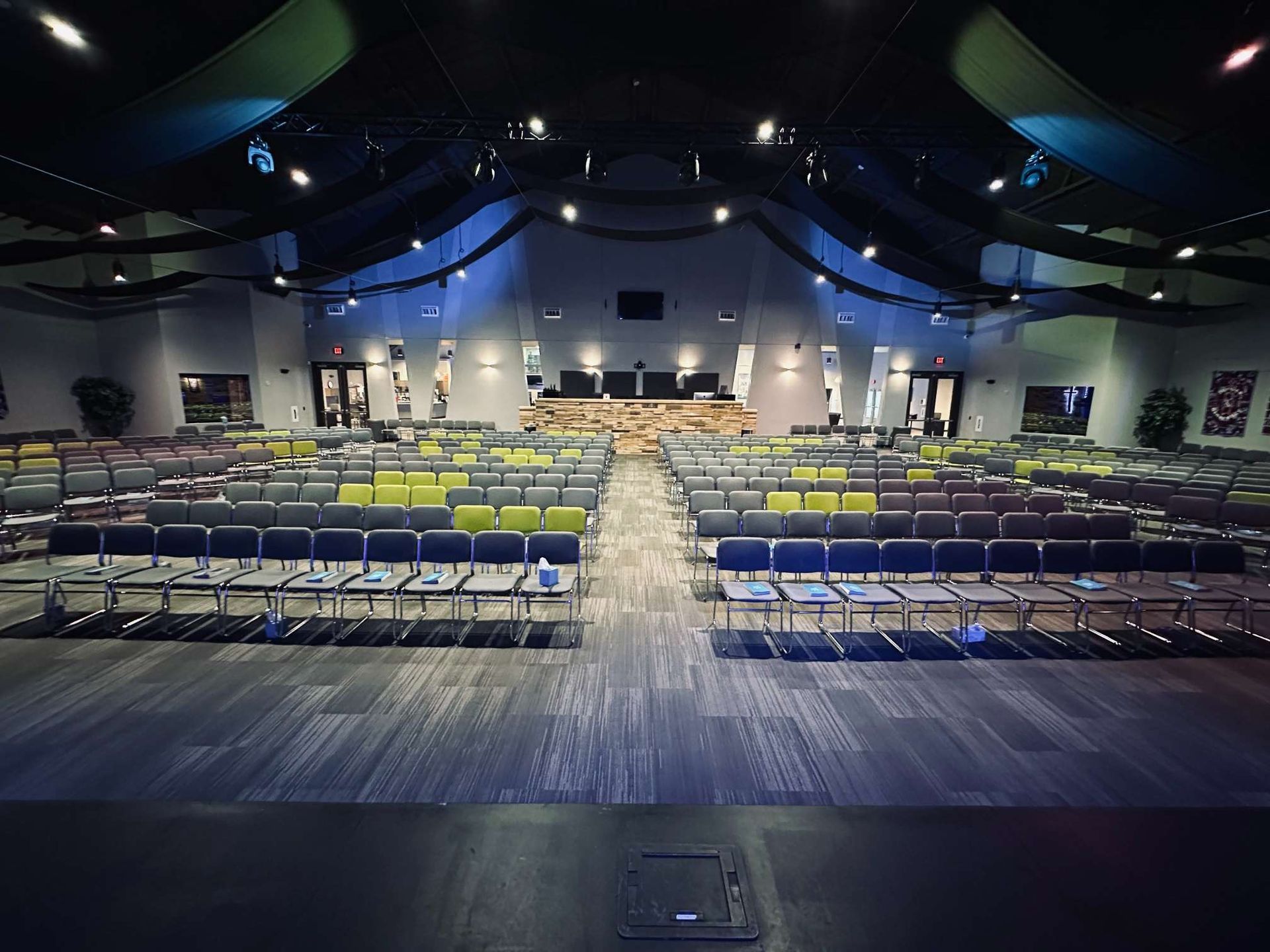 A large auditorium with rows of chairs and a stage