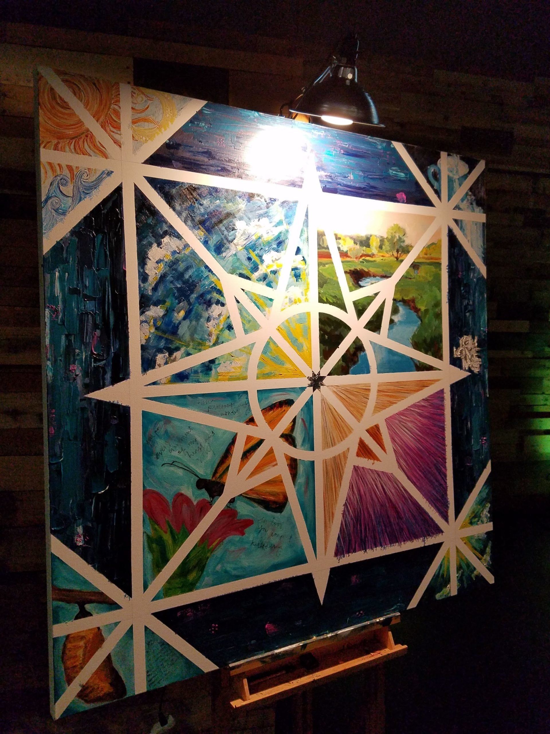 A large painting is hanging on a wall with a light shining on it