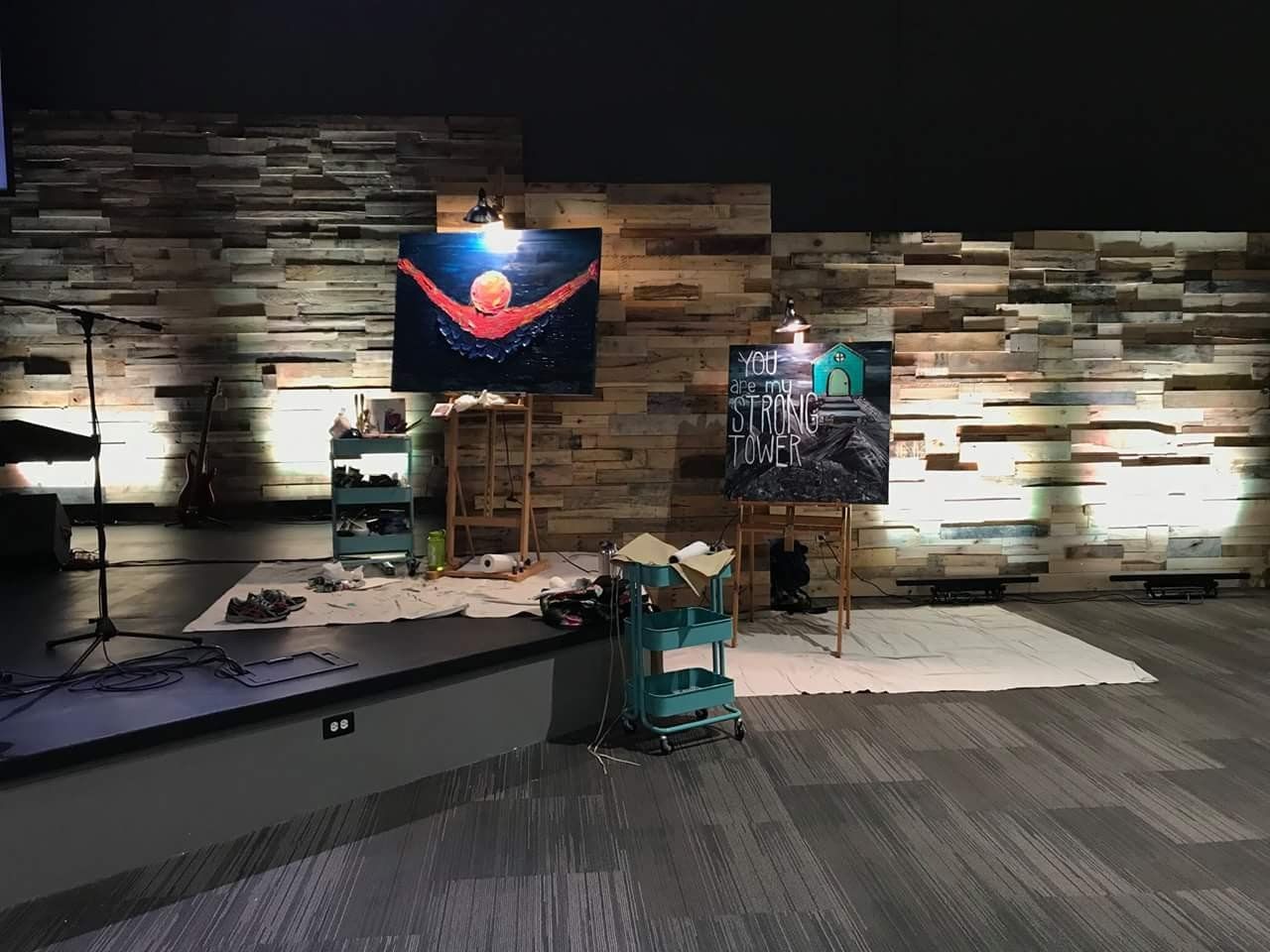 There is a painting on an easel in the middle of the room.