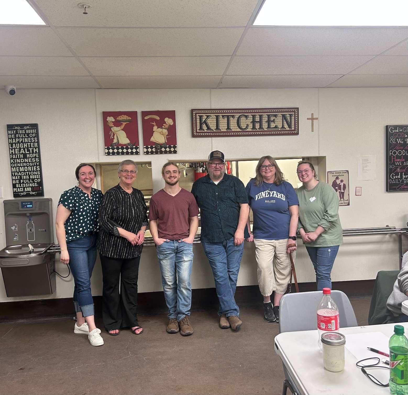 A group of people are posing for a picture in a kitchen.
