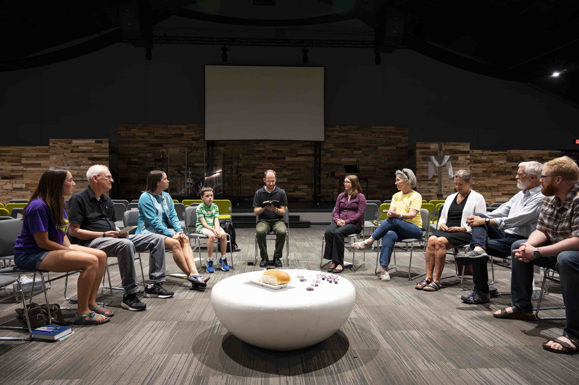 A group of people are sitting in a circle around a table.