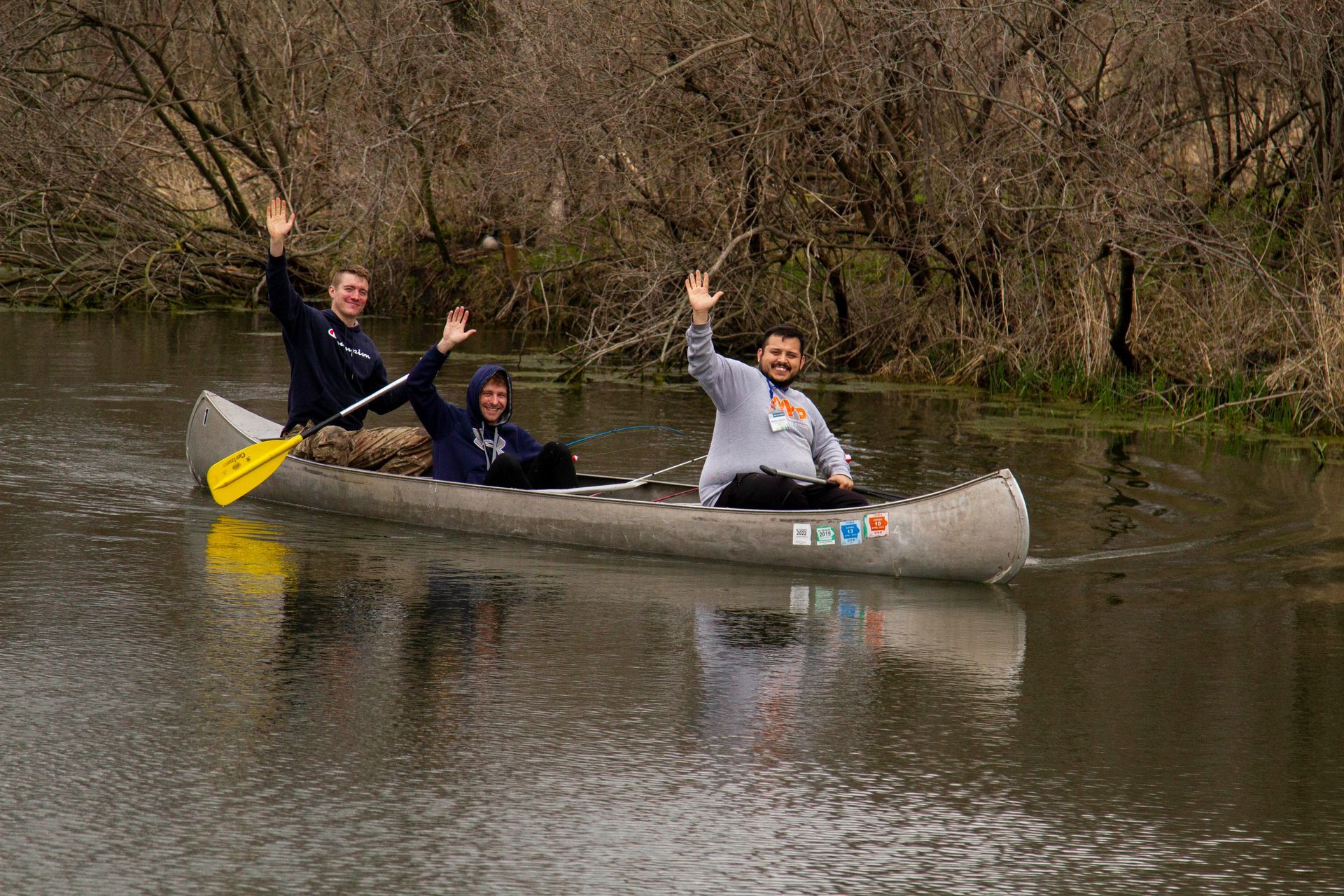 Three people are in a canoe on a river.