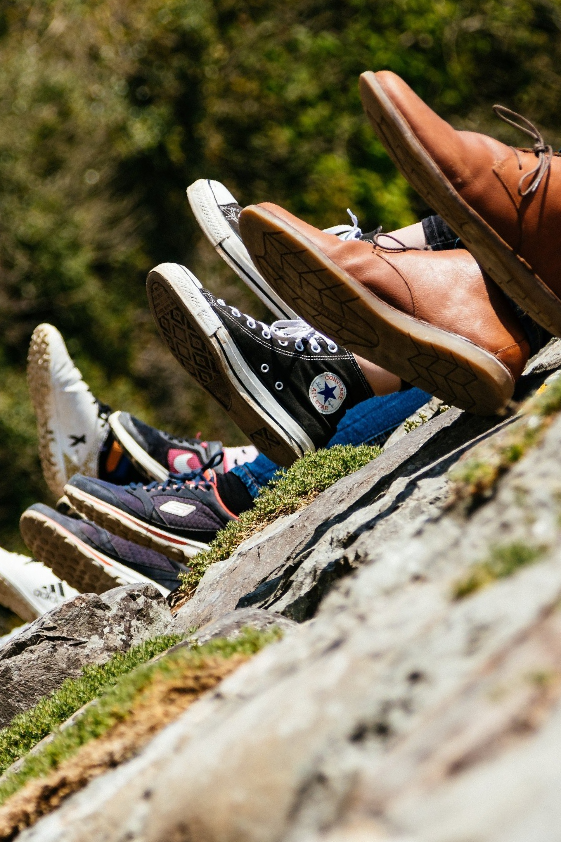 A group of people 's feet are lined up on a rock.