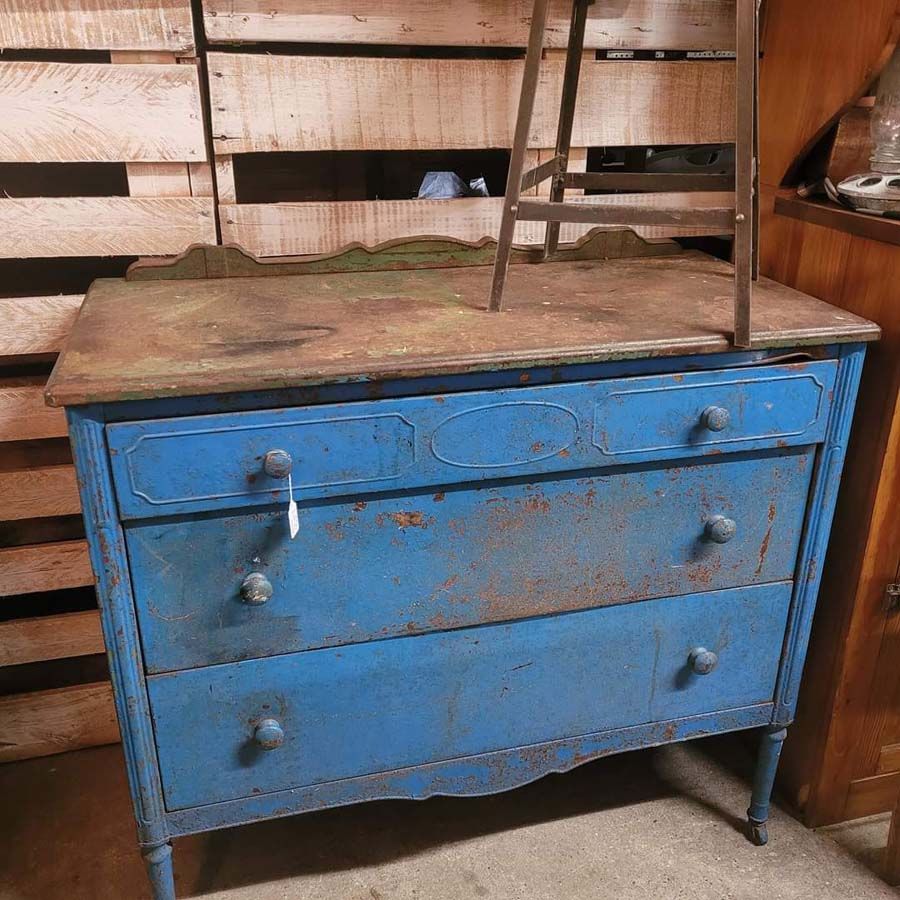 Blue dresser with three drawers, metal hardware, and wooden tabletop.