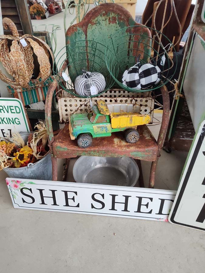 Green and rusty chair with a toy truck and pumpkins. 