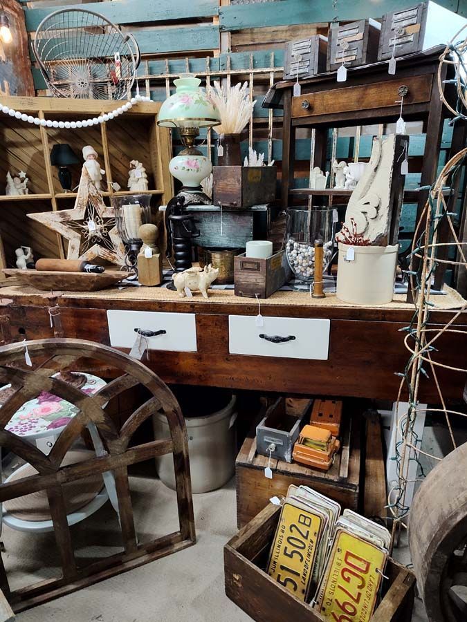 Antique shop display with wooden furniture, vintage items, and decorative elements.