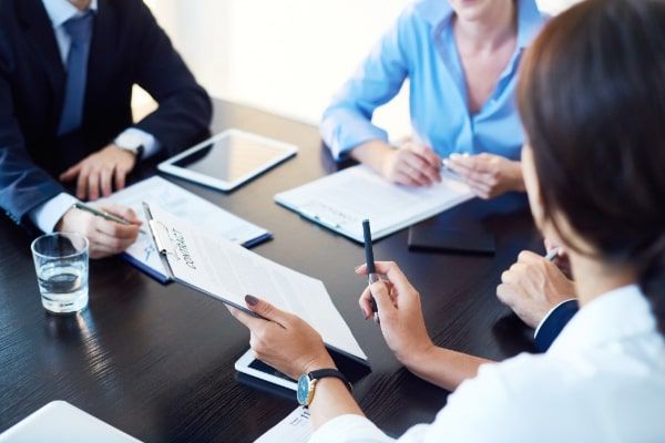 A group of people are sitting around a table having a meeting.