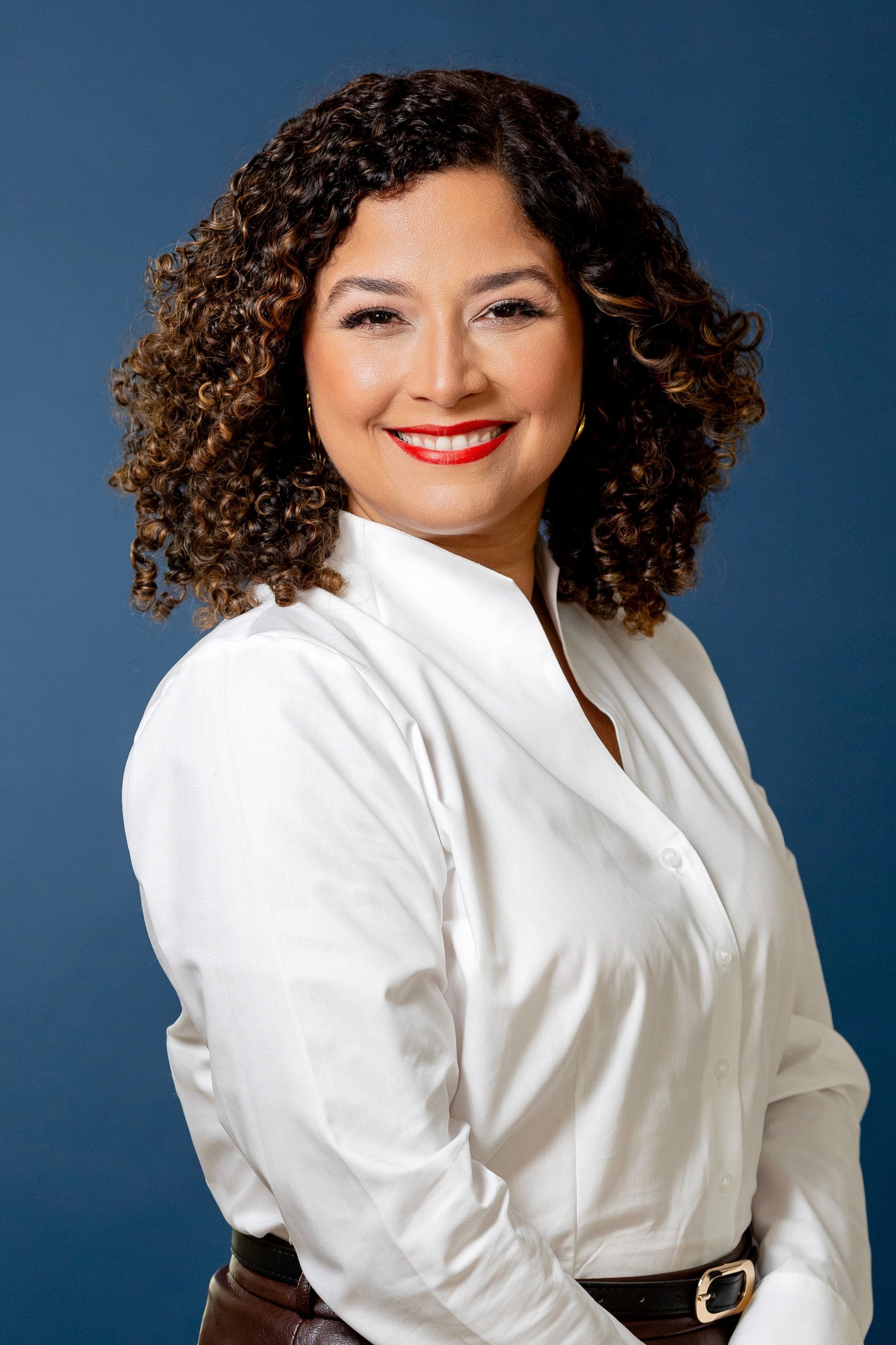 Nayka Rivera in a white blazer against a blue background