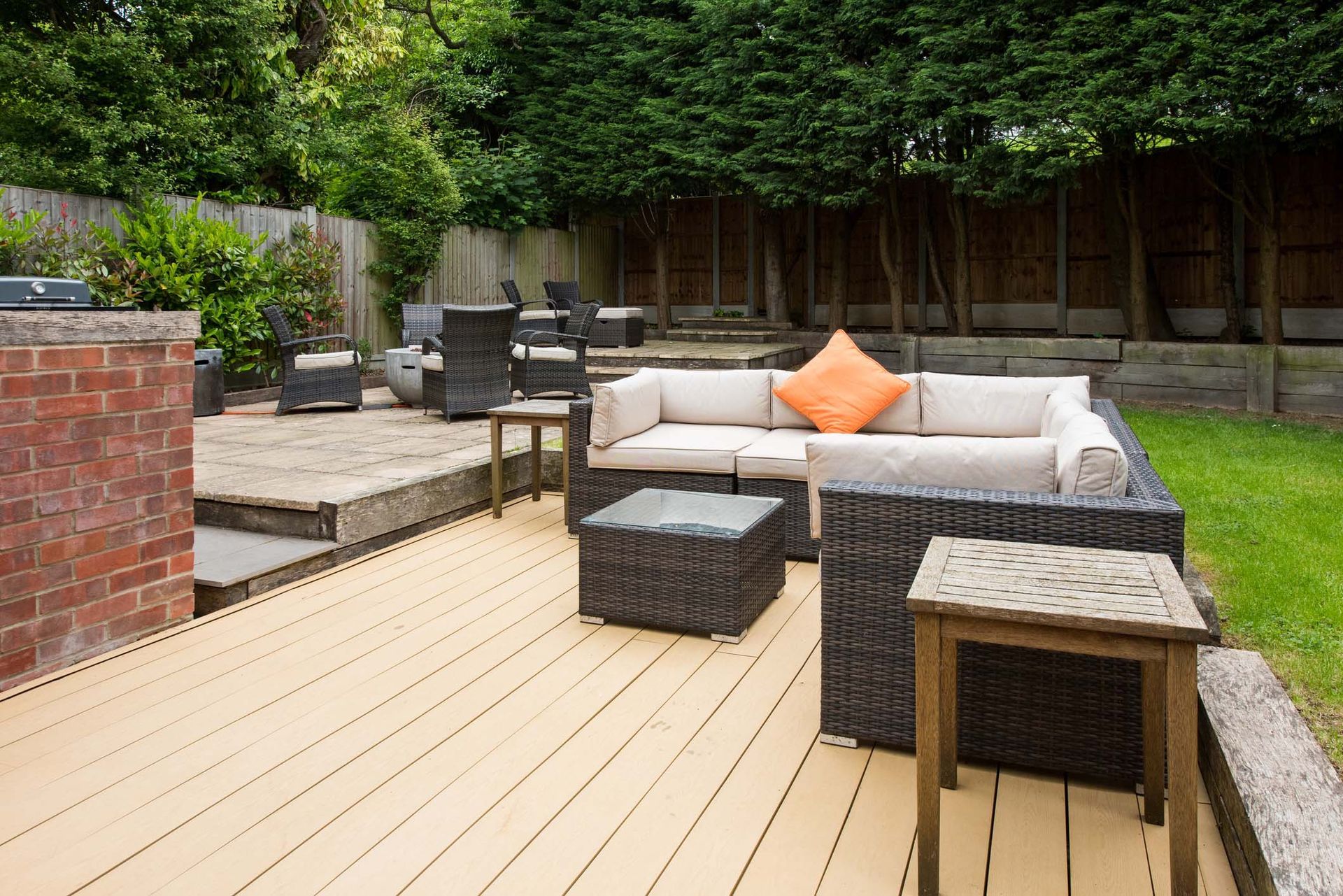 A wooden deck with a couch and chairs on it.