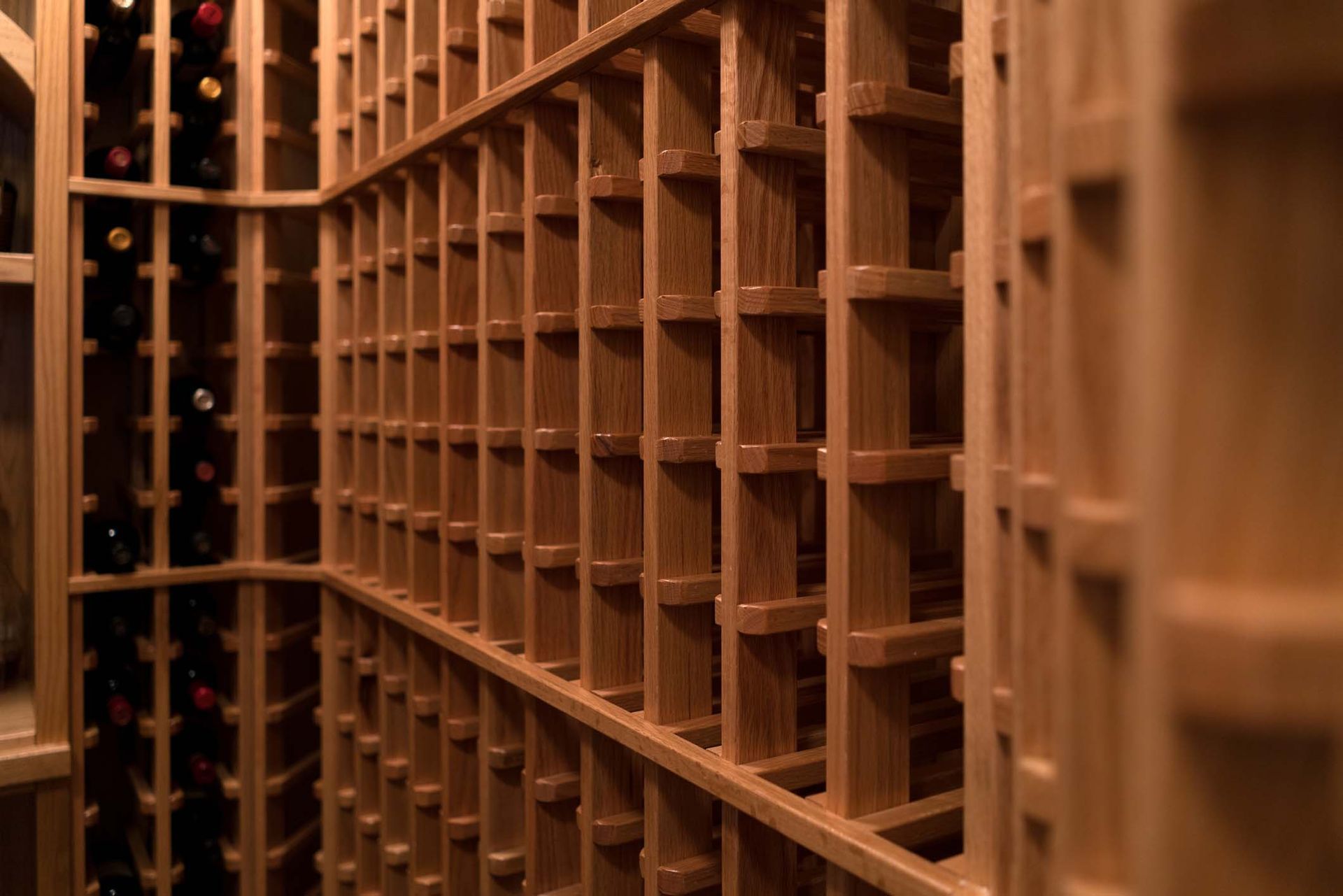 A wooden wine cellar filled with lots of wine bottles.