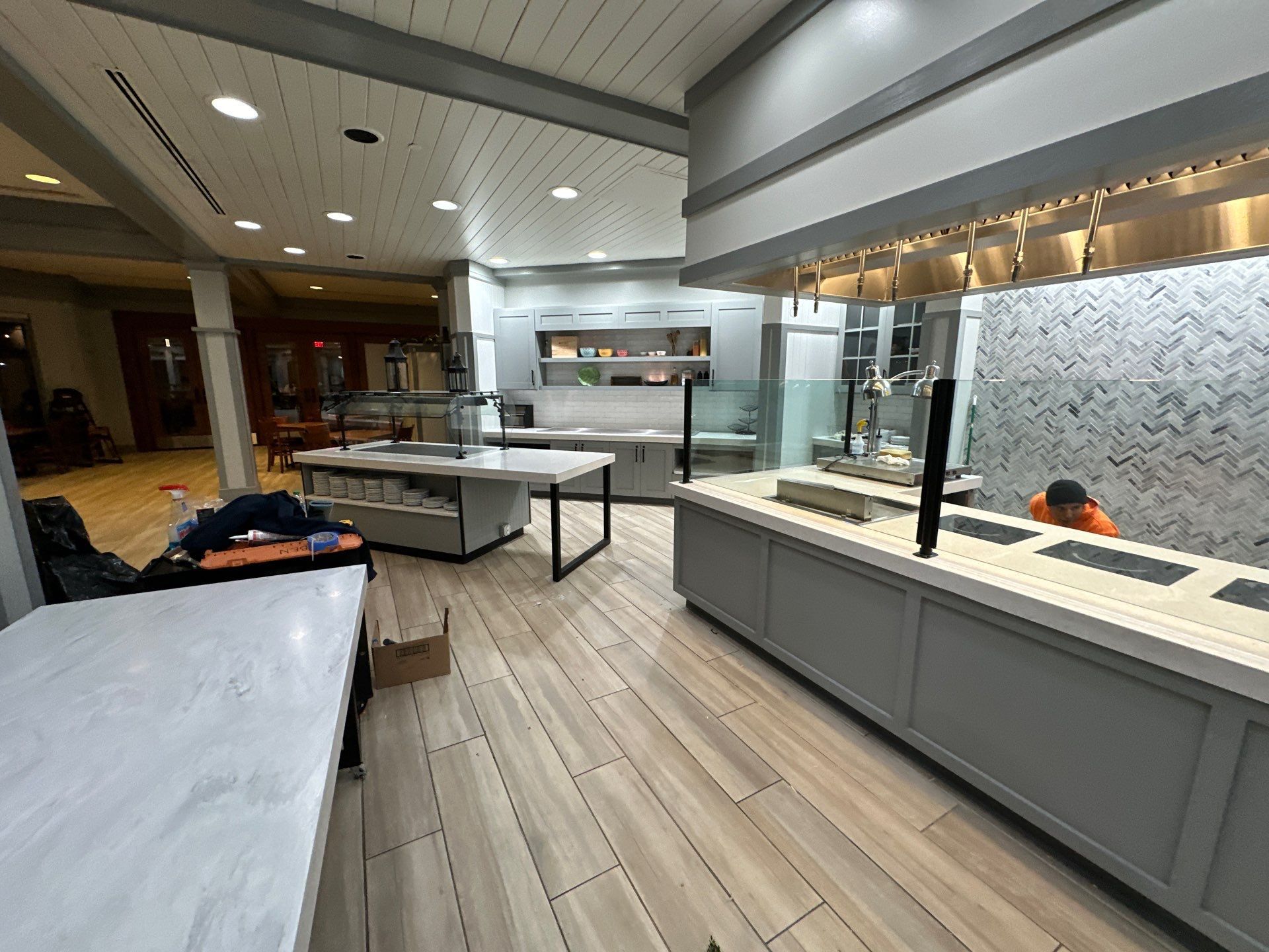 A large commercial kitchen with a lot of counters and tables.