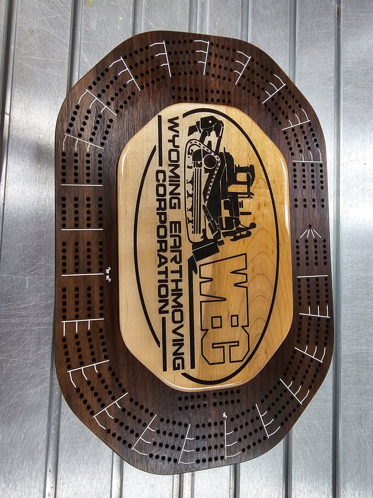 A wooden cribbage board that says wyoming earthmoving corporation