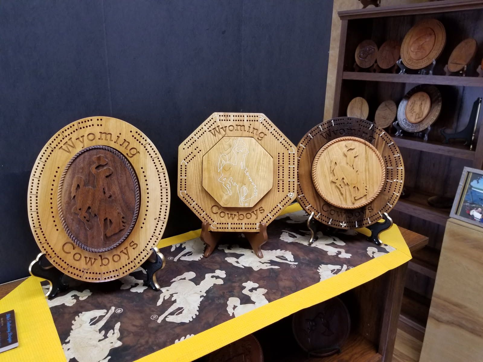 Three wooden plates with wyoming cowboys written on them