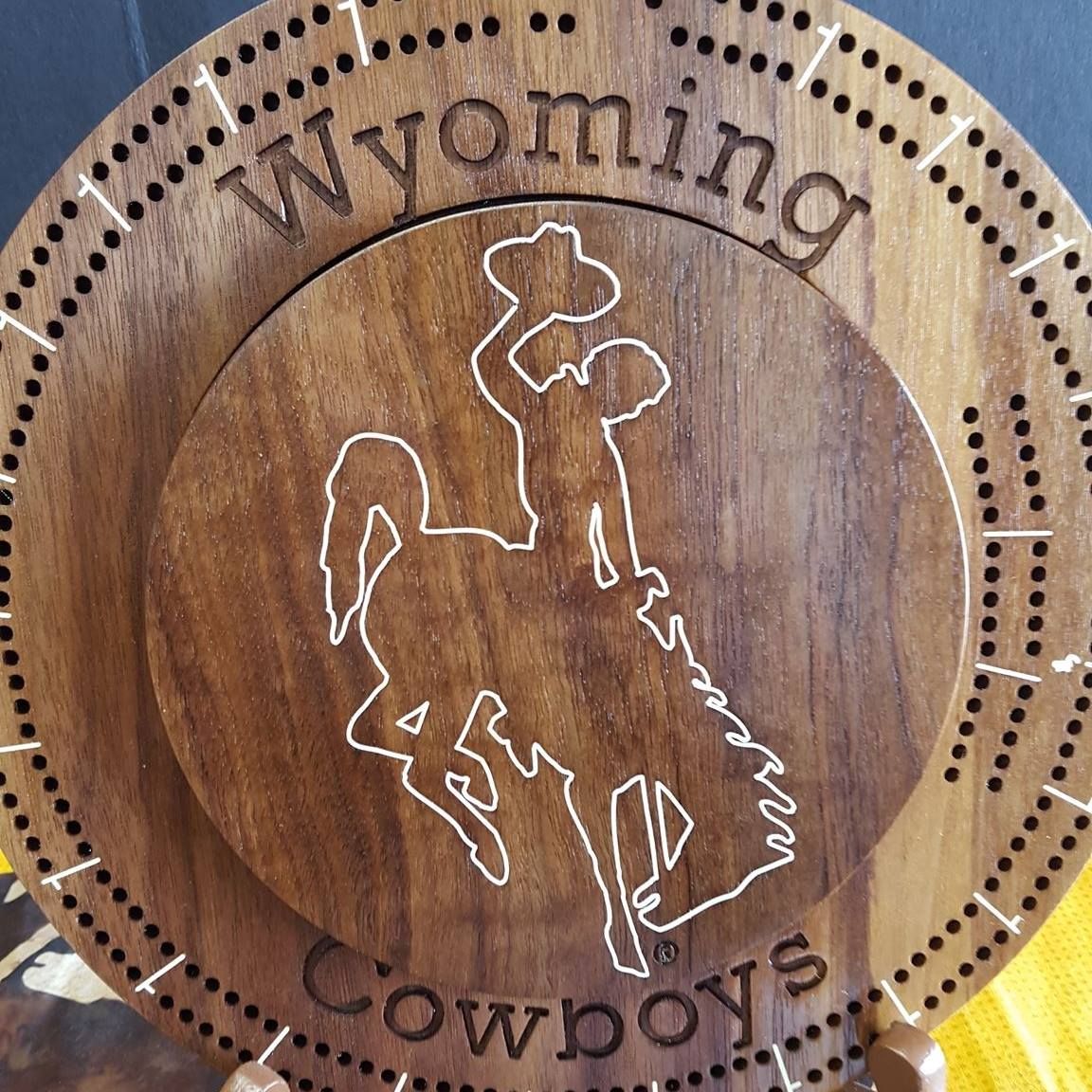A wooden plate that says wyoming cowboys on it