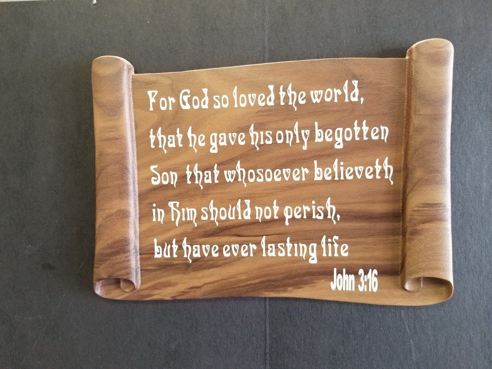 A scroll with a quote from john 3:16 on it