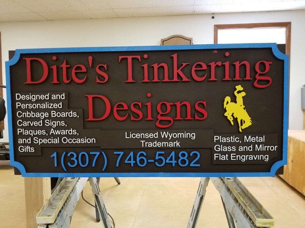 A sign for dite 's tinkering designs is displayed in a room