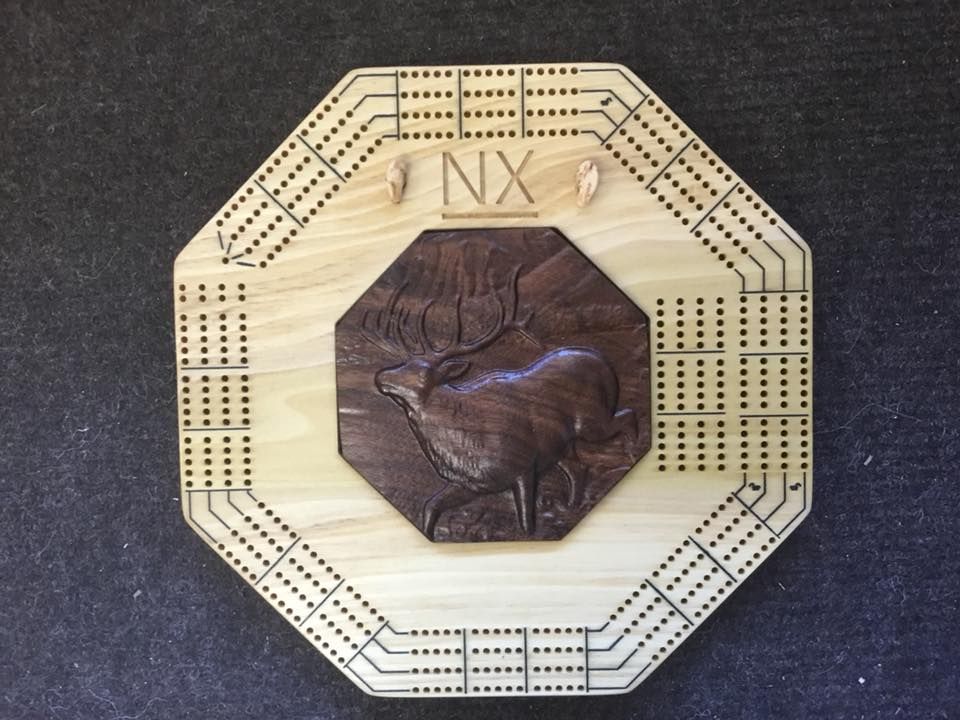 A wooden cribbage board with a picture of a deer on it