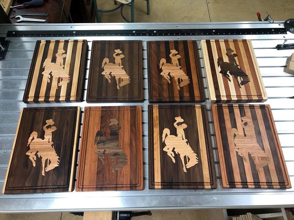 A bunch of wooden cutting boards with cowboys on them
