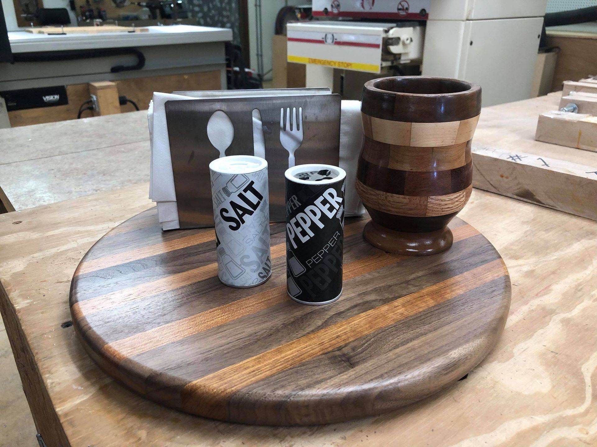 A wooden cutting board with salt and pepper shakers on it