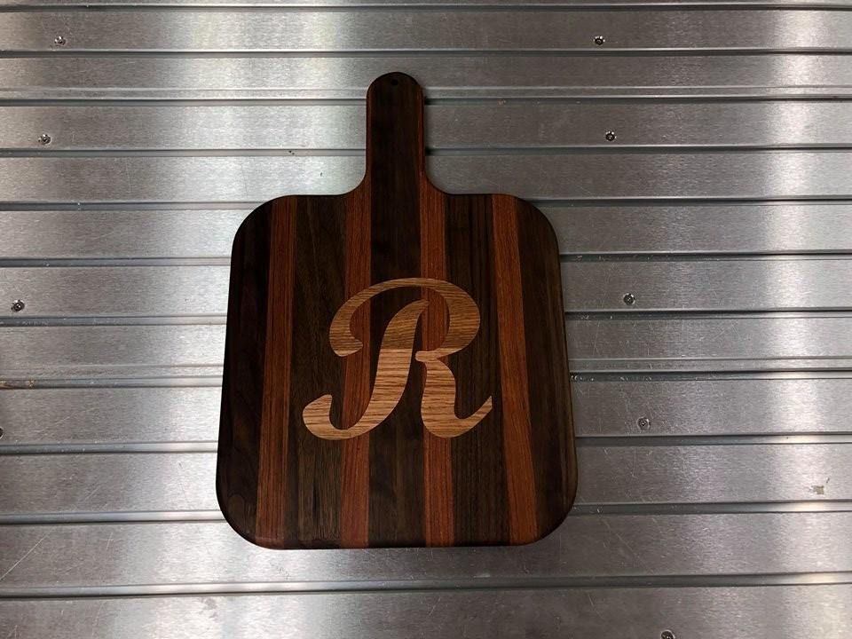 A wooden cutting board with the letter r engraved on it