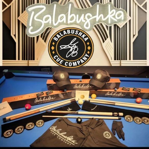 Products from Balabushka Cue Company on a pool table, including cues, hats, and accessories.