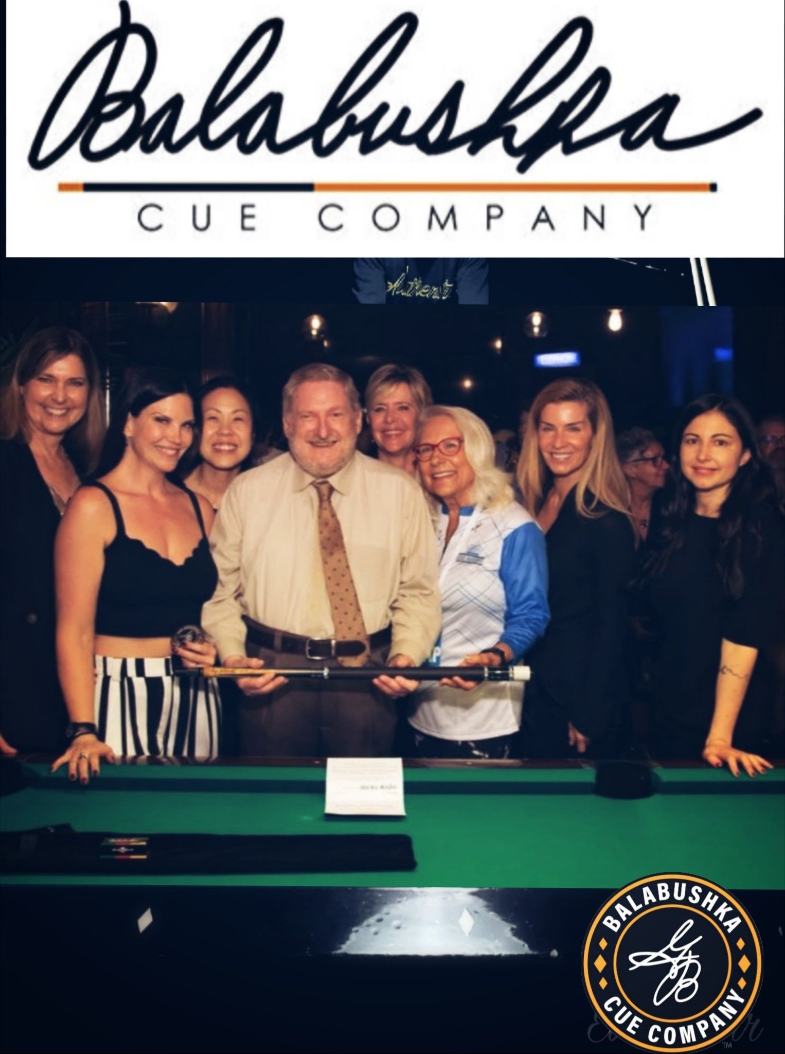 Group of people around a pool table holding a cue stick, Balabushka Cue Company logo at top.
