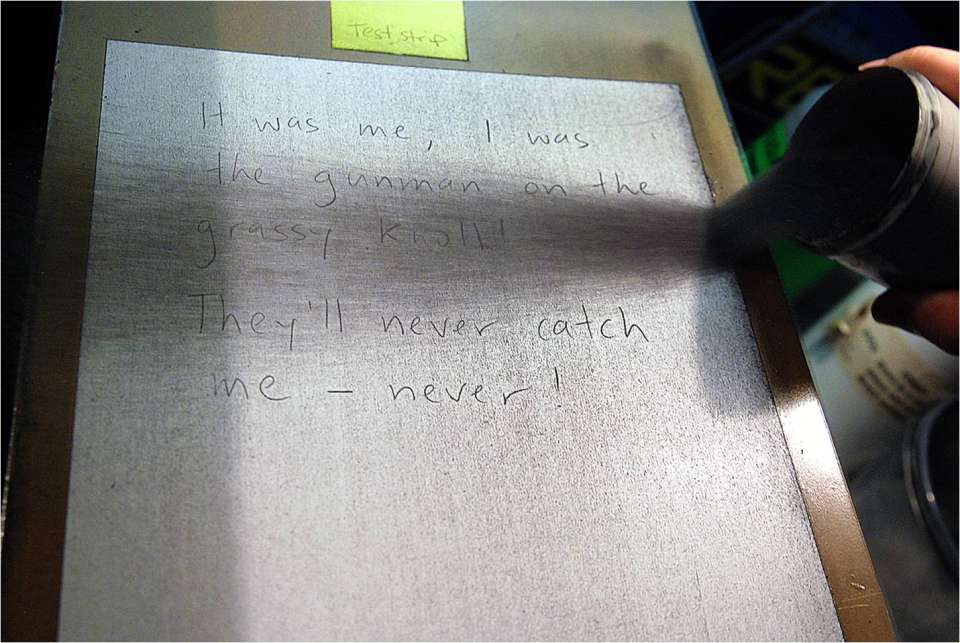 spraying chemical on paper to figure out what is written on it