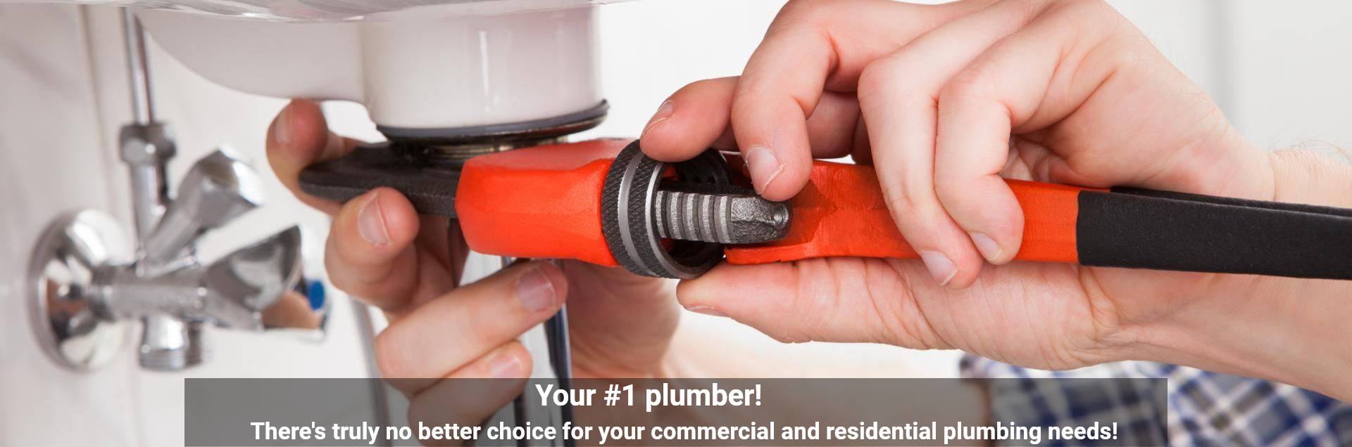 A plumber uses a large, bright orange pipe wrench to tighten a connection under a sink.