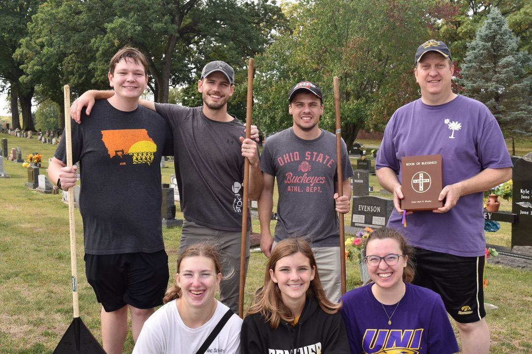 A group of young people posing for a picture in a cemetery