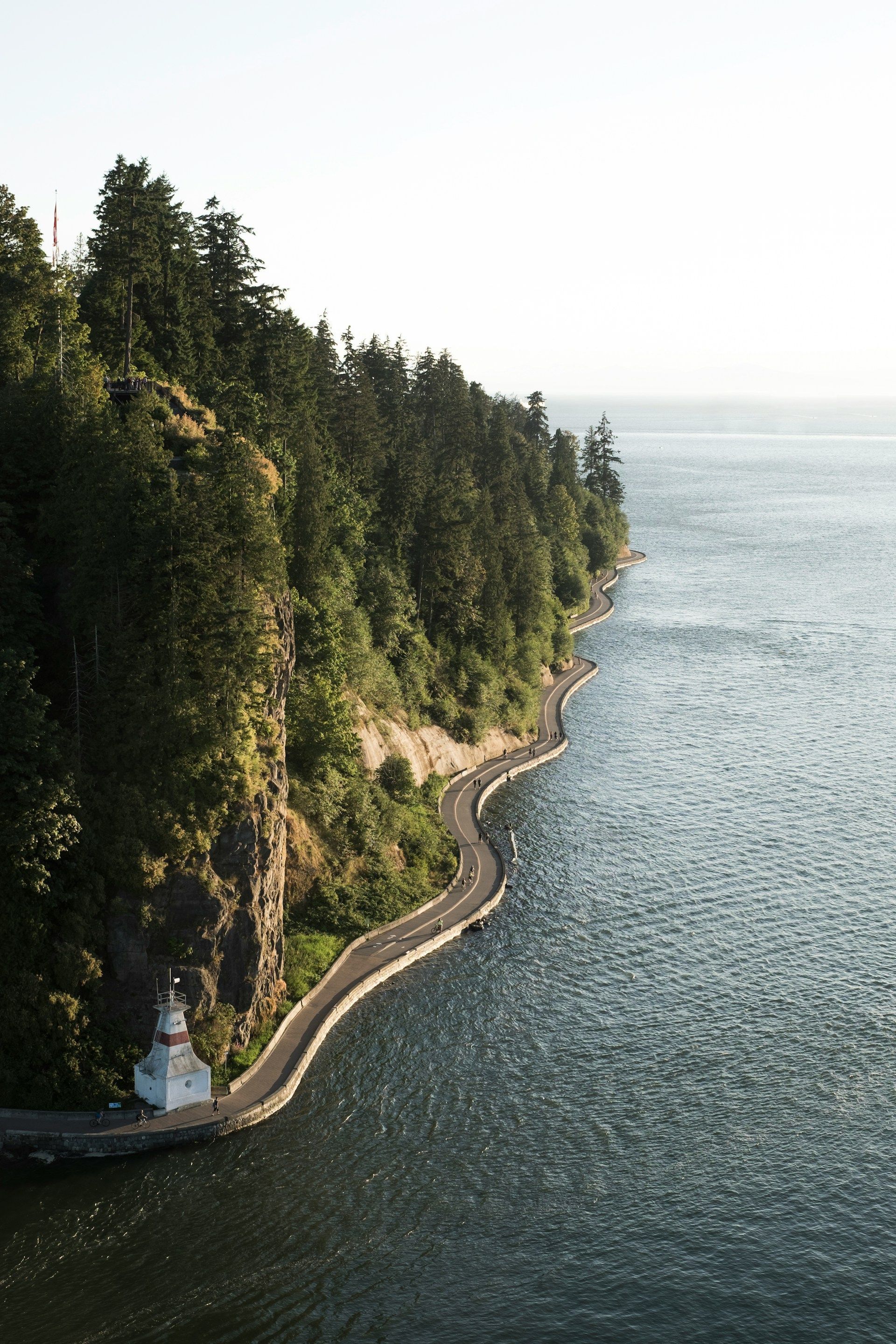 A road runs along a cliff overlooking a body of water