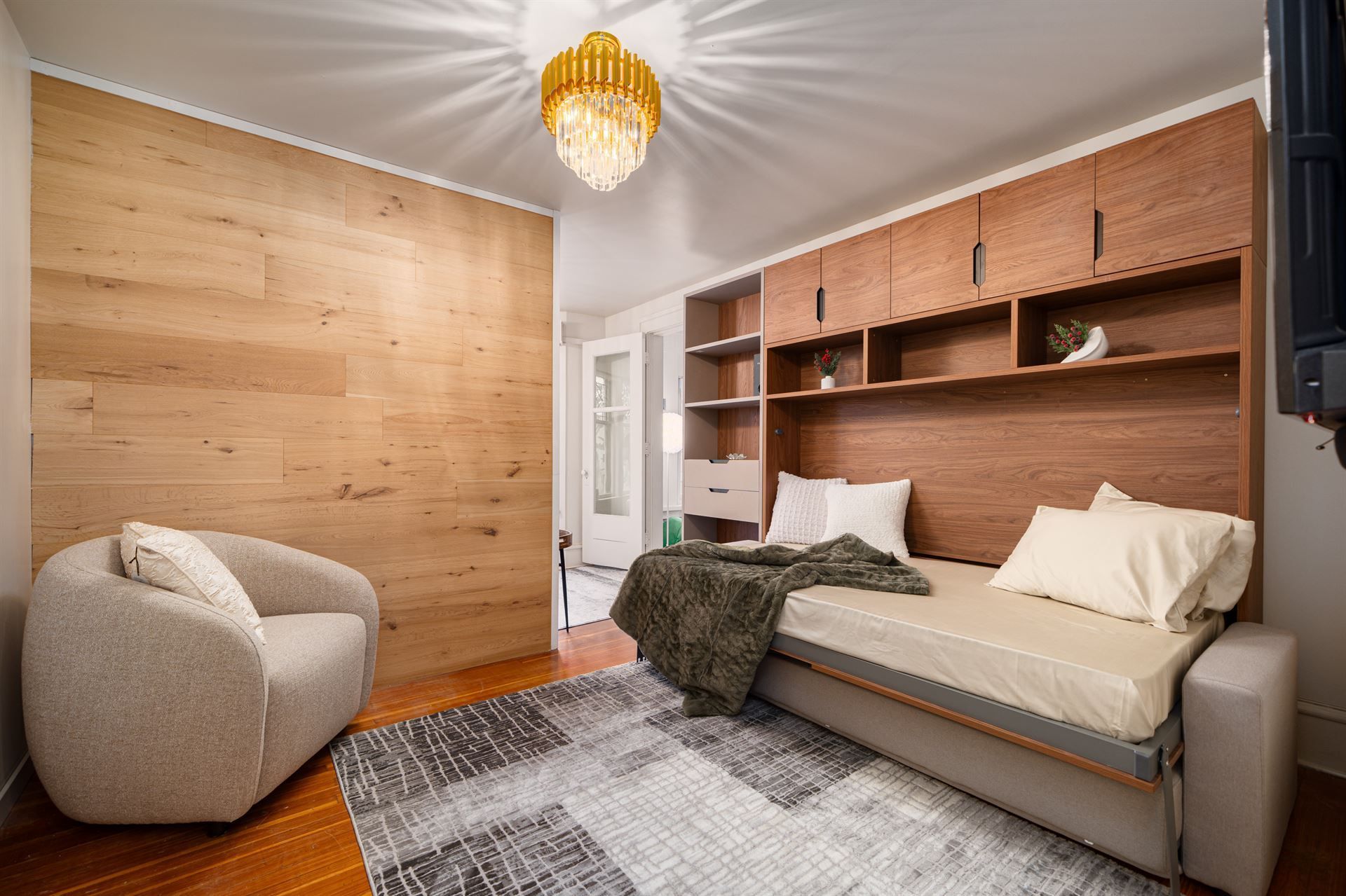 A bedroom with a bed , chair , and television.