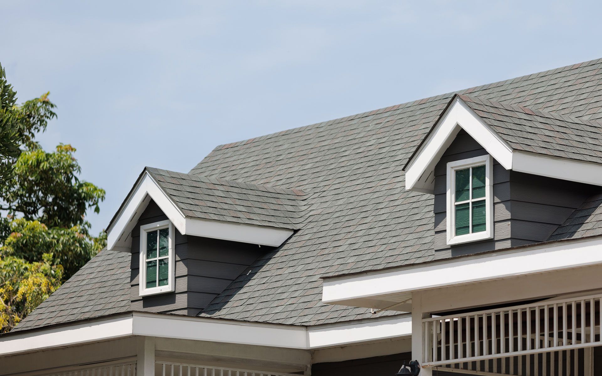 The roof of a house with two windows on it.