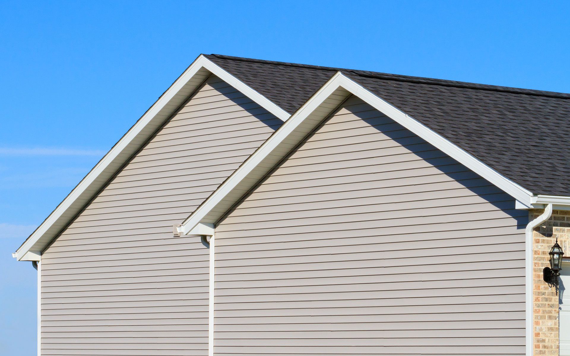 The roof of a house with a blue sky in the background.