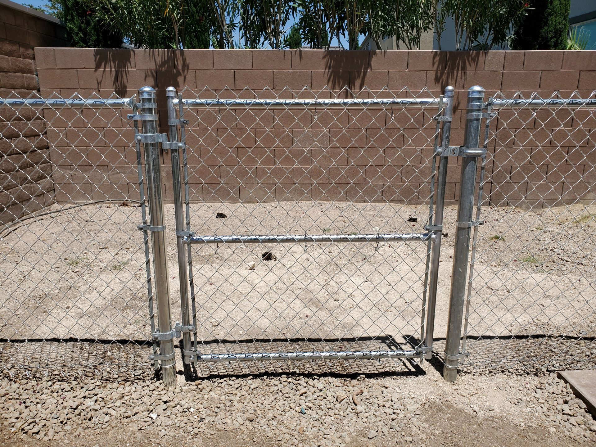 Chain link fence with an ice cream truck driving on the road behind it.