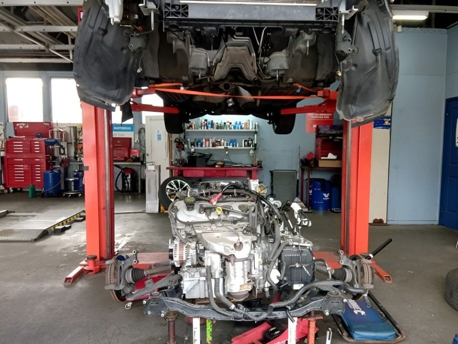 A Car With the Engine Removed is on a Lift in a Garage — AVA Automotive Repairs in Oak Flats, NSW