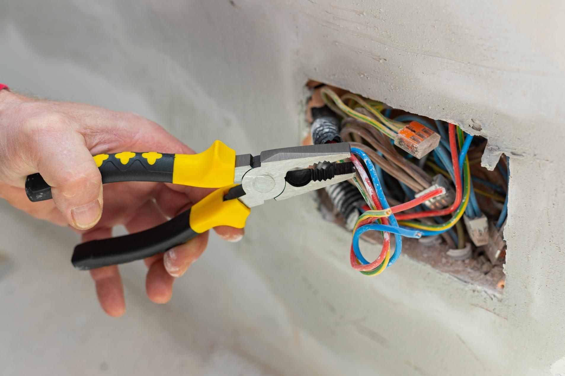 Person is Using a Pair of Pliers — Robbie McDonald Electrical in Golden Beach, QLD