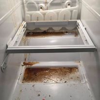 The inside of a refrigerator is very dirty and needs to be cleaned.